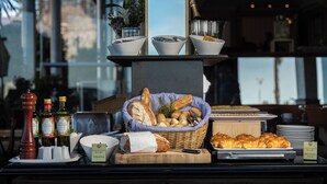 Un bufé de desayuno con panes, pasteles y salsas.