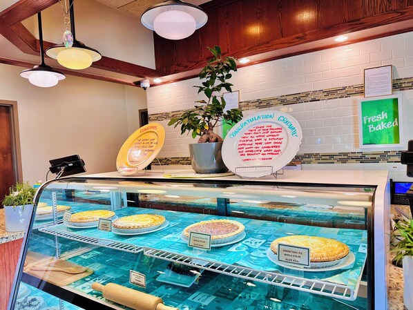 A bakery display case with various pies and a congratulatory sign. - Holiday Inn Hotel & Suites Regina by IHG (Regina)
