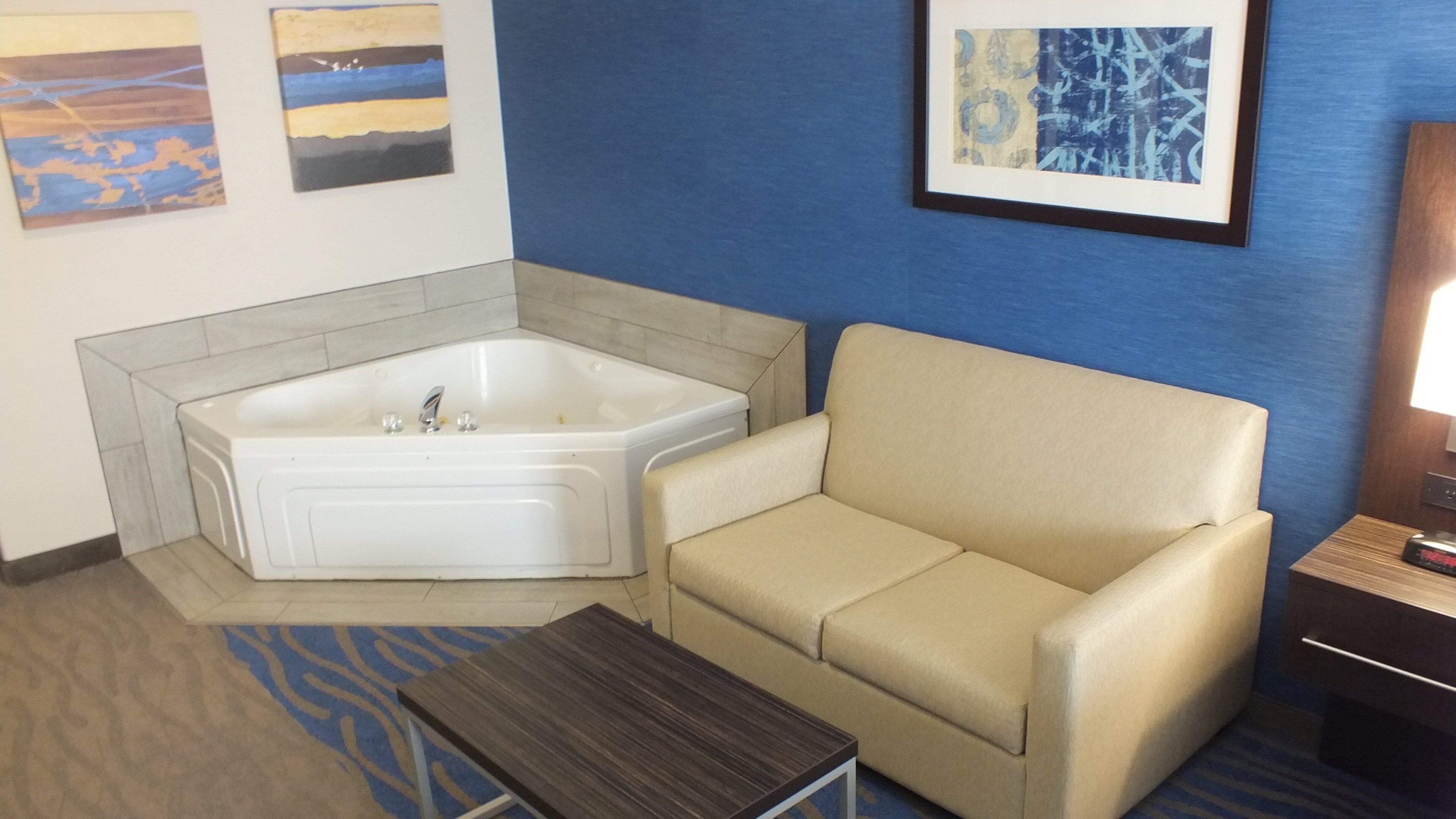 Un bagno con una vasca, un divano color beige e un tavolino.