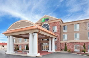 Edifício da Holiday Inn Express & Suites com entrada coberta, fachada de tijolos e várias janelas.