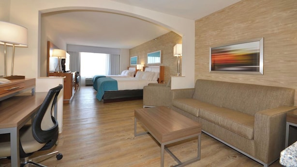 A hotel room with a bed, a sofa, a desk, and a chair. - Holiday Inn Express & Suites Farmington by IHG (Farmington)