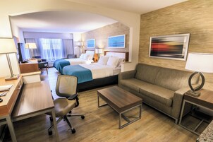 Una habitación de hotel con una cama, un sofá, un escritorio y una silla.