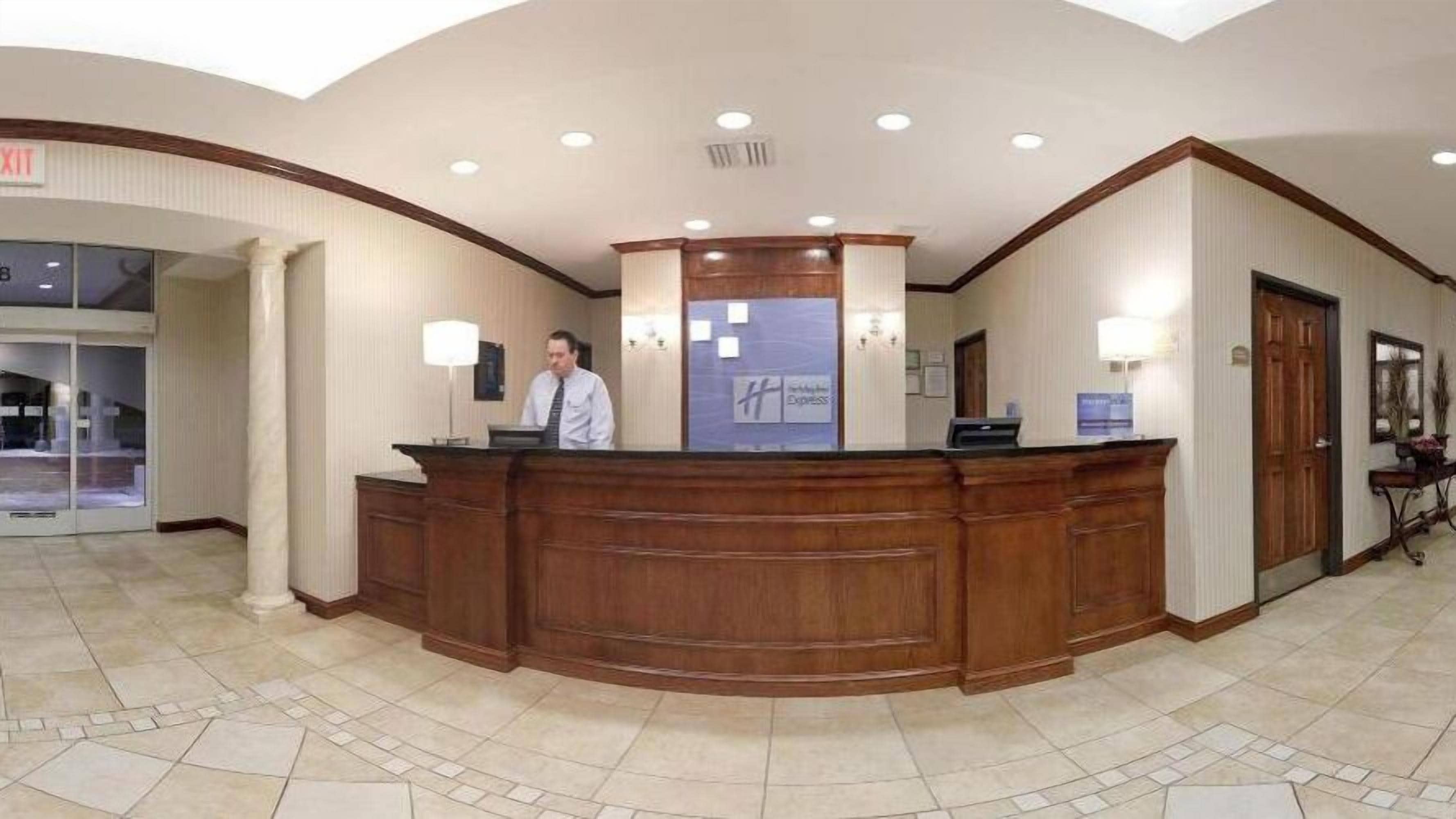 A reception desk with a man standing behind it, a sign for 'Express' on the wall, and a door to the right.