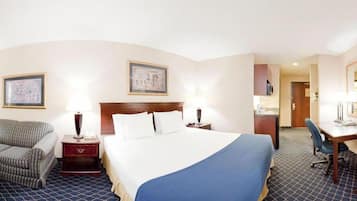 A hotel room with a large bed, two bedside tables, a desk, a chair, and a mirror.