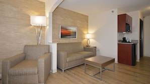 A modern living room with a sofa, armchairs, a coffee table, and a painting on the wall. - Holiday Inn Express & Suites Farmington by IHG (Farmington)