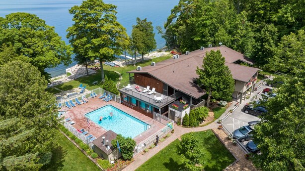Un complexe hôtelier doté d’une piscine, de chaises longues et offrant une vue sur la mer.
