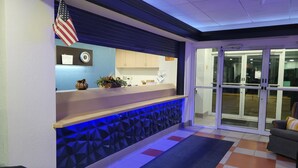 Un espace d’accueil avec un comptoir, une horloge et un drapeau américain.