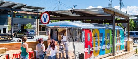 Un camion-restaurant aux couleurs vives, doté d’un espace de restauration couvert.