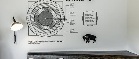 A wall with a diagram of Yellowstone National Park's Grand Prismatic Spring, including temperature zones and a bull elk illustration.