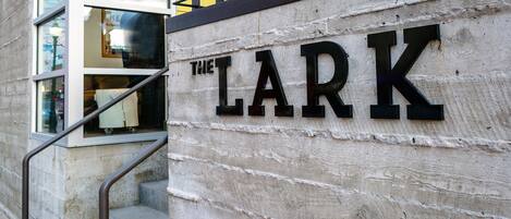 L’entrée d’un immeuble, avec une enseigne portant l’inscription « THE LARK ».