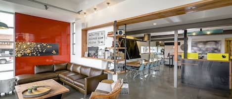 A modern interior with leather seating, a reception desk, and a visible sign with directions.