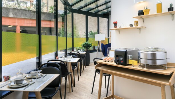 Un comedor moderno con paredes de vidrio, un sistema de buffet y vistas al exterior.
