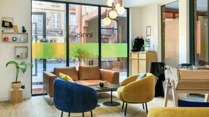 Una sala moderna con un sofá, dos sillones, una mesa de centro y una mesa de comedor con sillas.