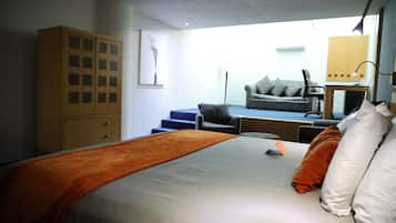 Una camera da letto con un letto, un armadio, un divano e una scrivania.