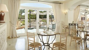 A spacious room with a large glass door leading to an outdoor area, furnished with a round table and four chairs. - Almar Giardino di Costanza Mazara del Vallo Resort & Spa (Mazara del Vallo)