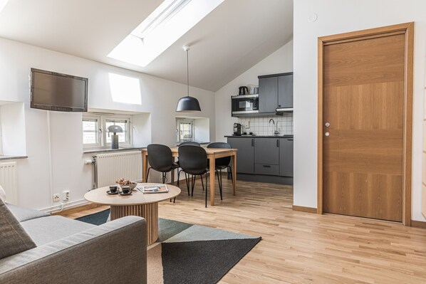 Um apartamento moderno com área de jantar, cozinha e sala de estar.