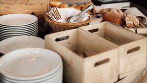 A breakfast buffet with various breads, pastries, and utensils. - The More Hotel Mazetti (Malmö)
