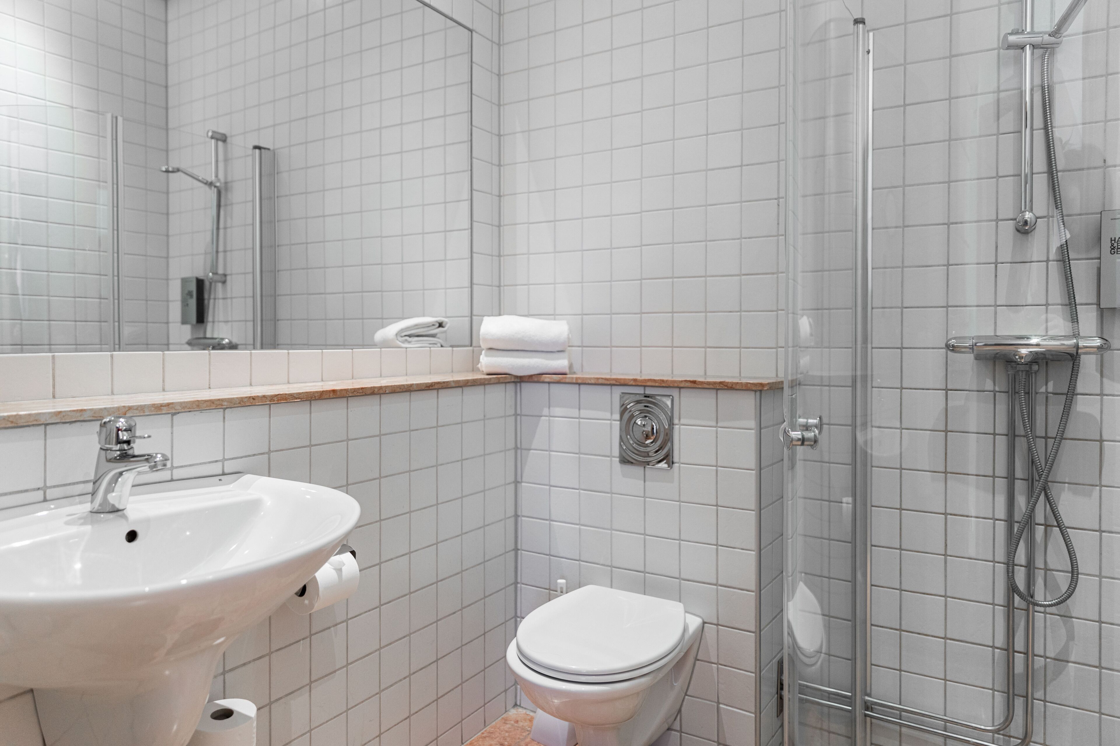 A bathroom with a sink, toilet, and shower.