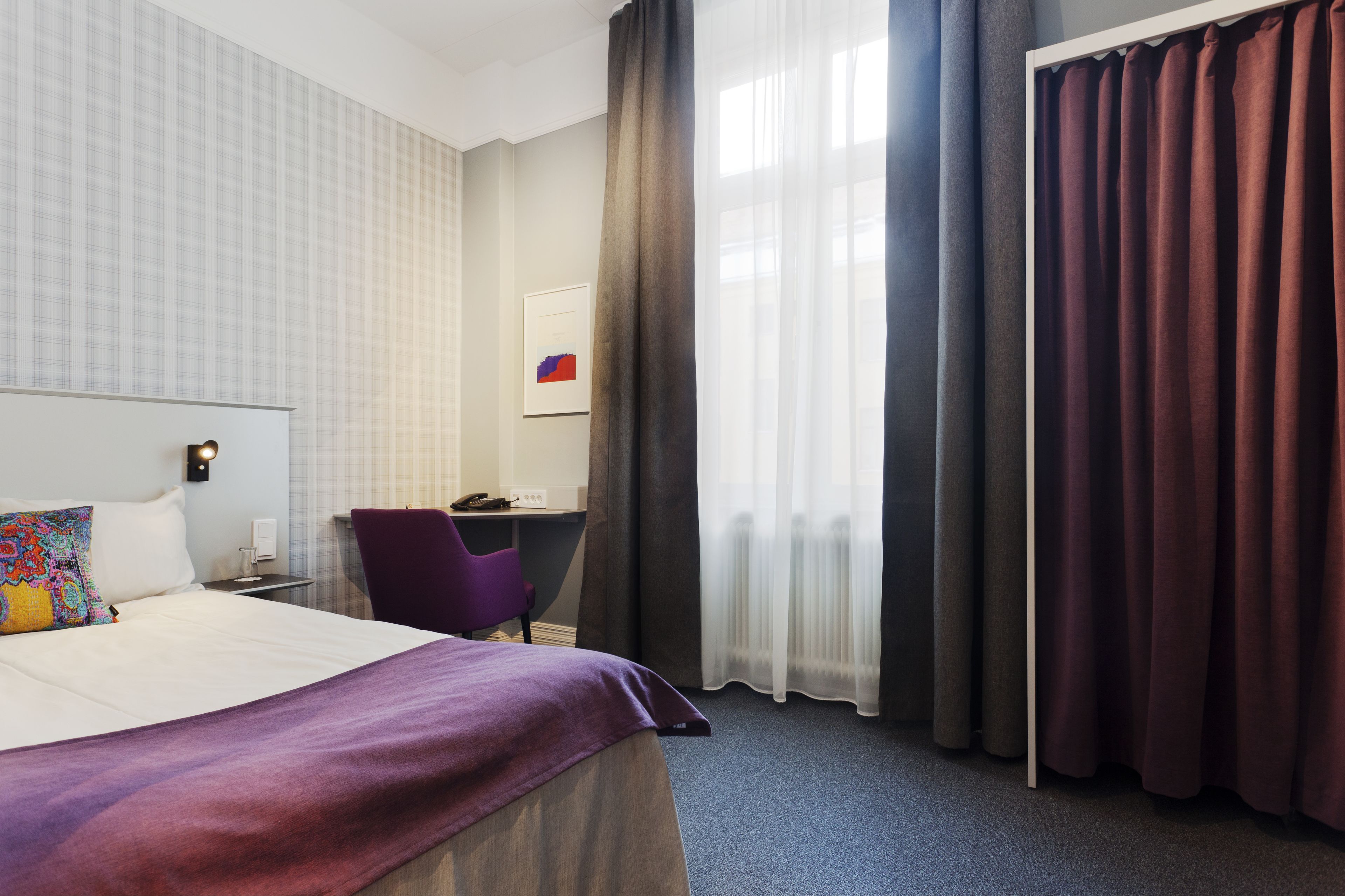 Una habitación de hotel con una cama grande, un escritorio y una silla.