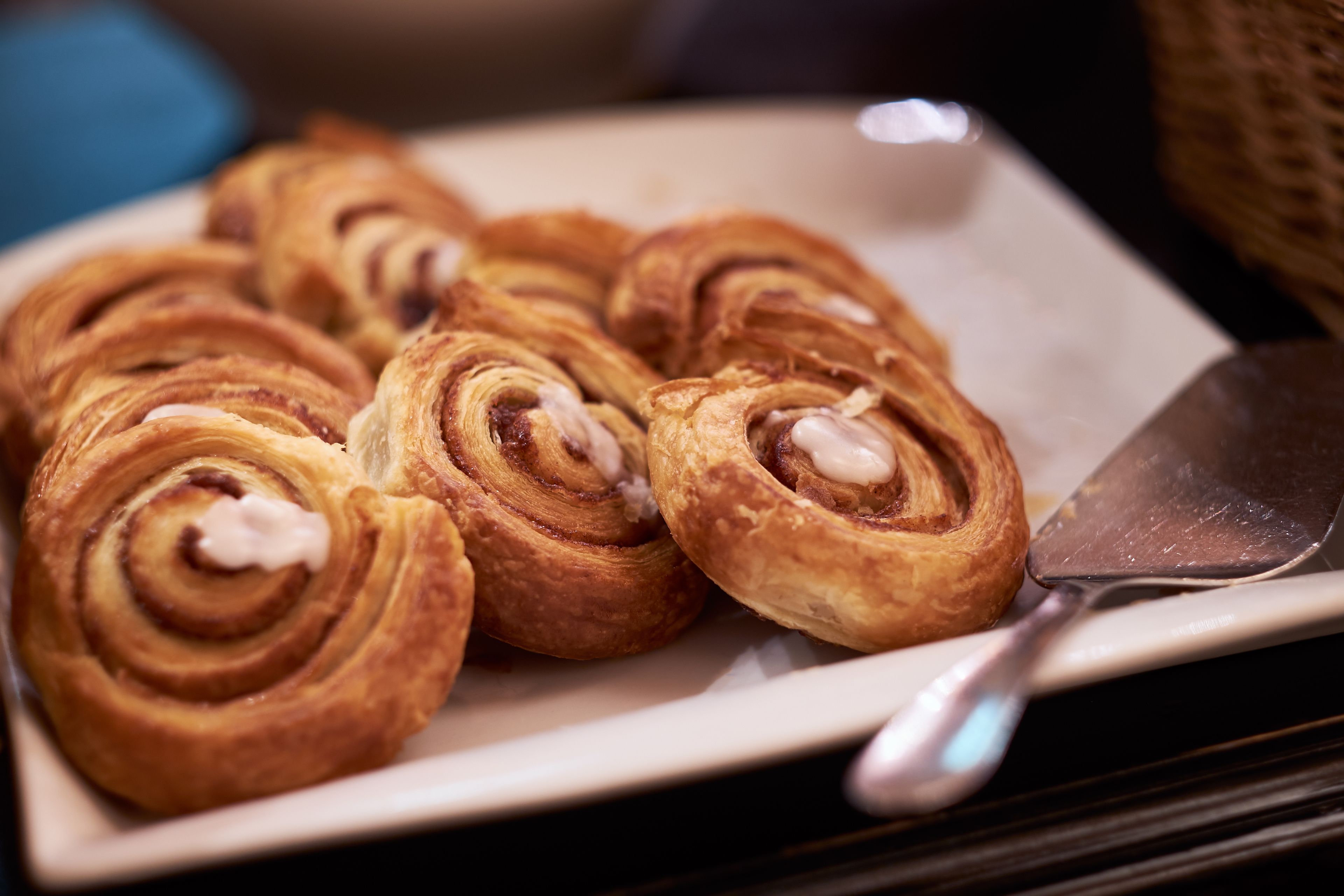 Un plato de rollitos de canela con crema sobre un plato blanco.