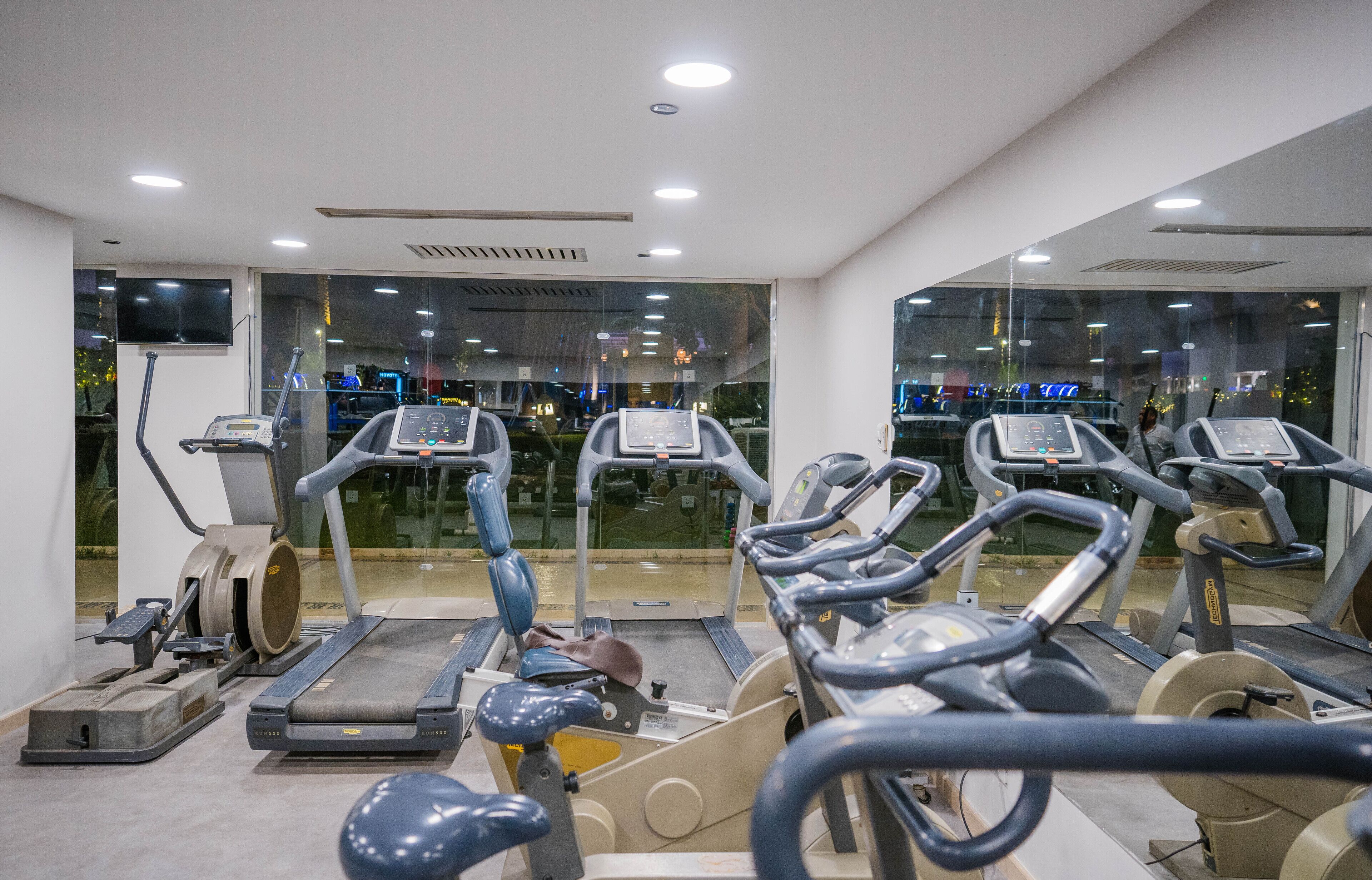 A gym with multiple treadmills, a stationary bike, and a rowing machine.