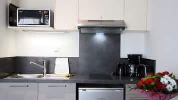 Una cocina moderna equipada con microondas, estufa, lavaplatos y pileta.