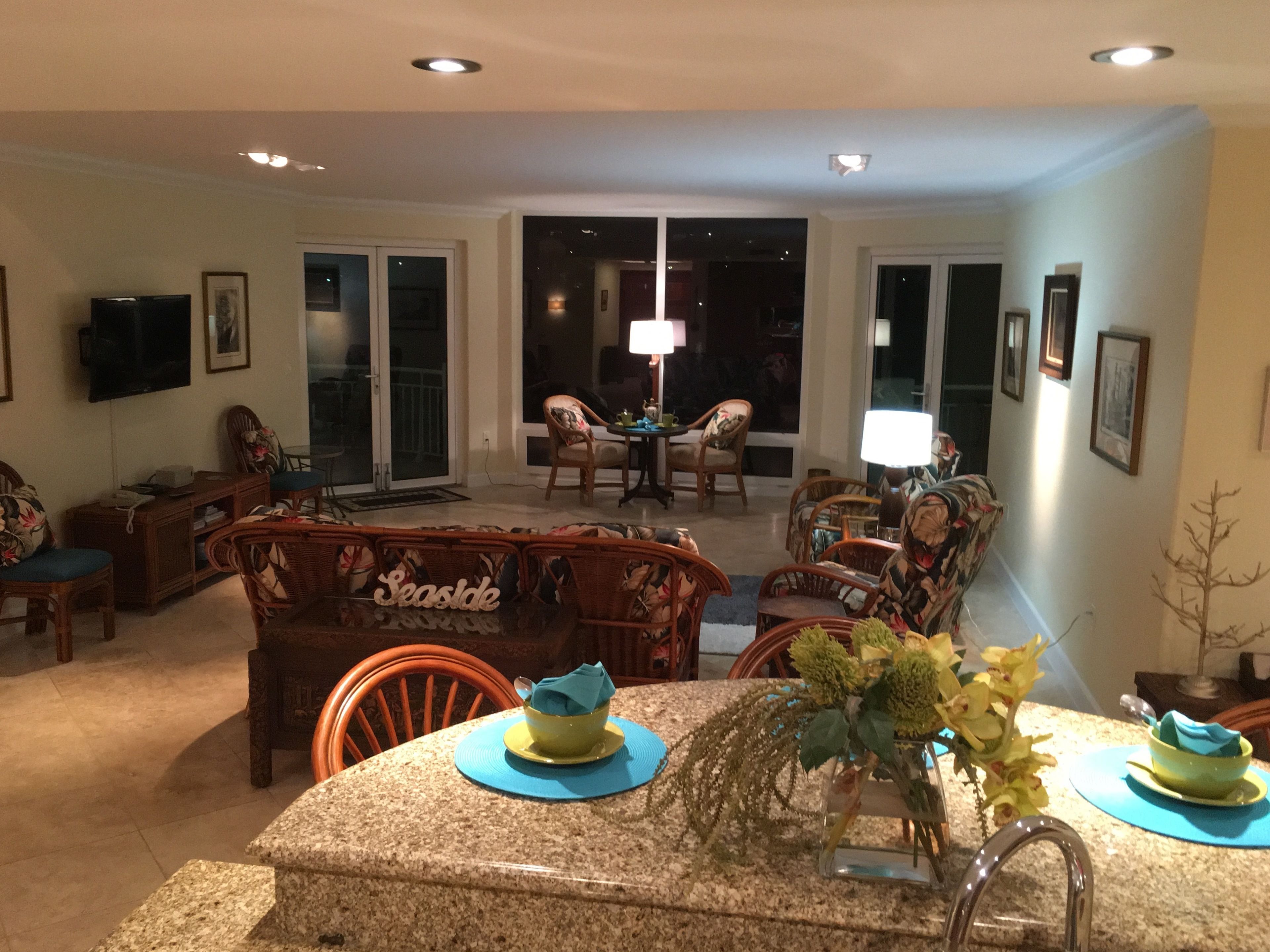 A dining area with a granite table, chairs, and a vase with flowers.