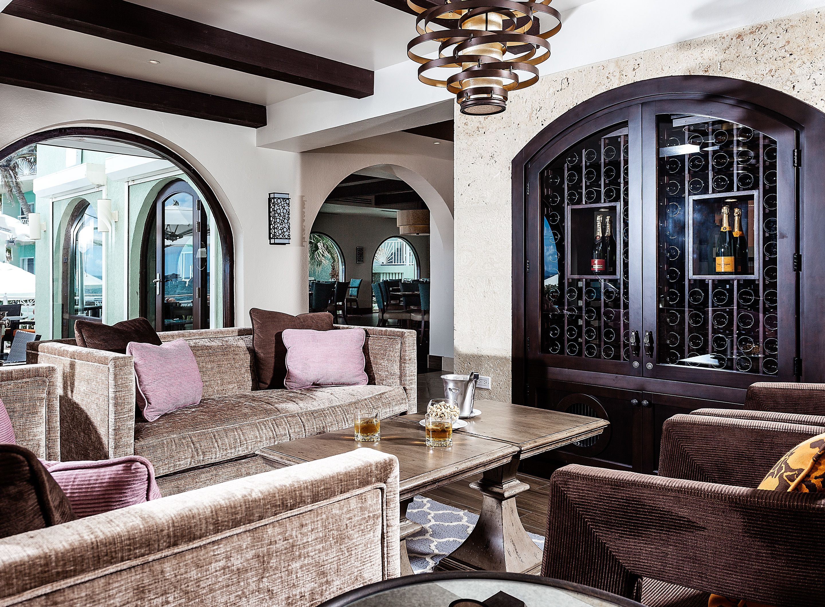 A cozy lounge area with a sofa, chairs, and a wine rack.