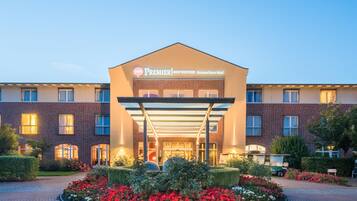 En hotelindgang med et overdækket gelænder, en murstensfacade og et skilt med teksten 'Premier Best Western Castanea Resort Hotel'.