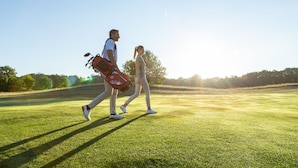 Two people walking on a grassy field with a clear sky. - Best Western Premier Castanea Resort Hotel (Adendorf)
