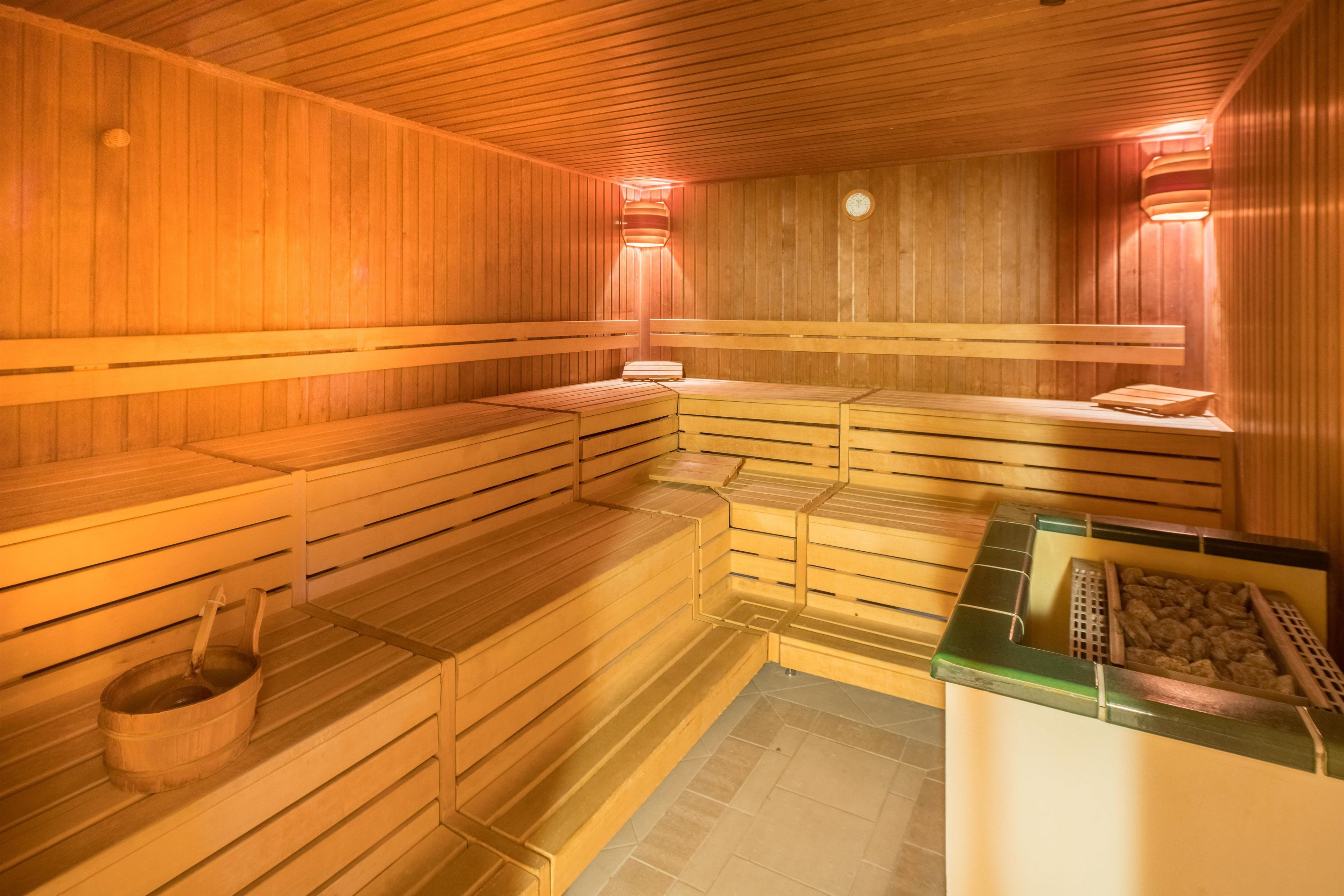 En sauna med træbænke og stengulv.