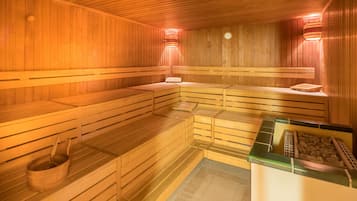 En sauna med træbænke og stengulv.