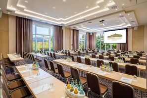 A conference room with multiple tables, chairs, and a large screen displaying 'CASTANEA FORUM ADENDORF'. - Best Western Premier Castanea Resort Hotel (Adendorf)