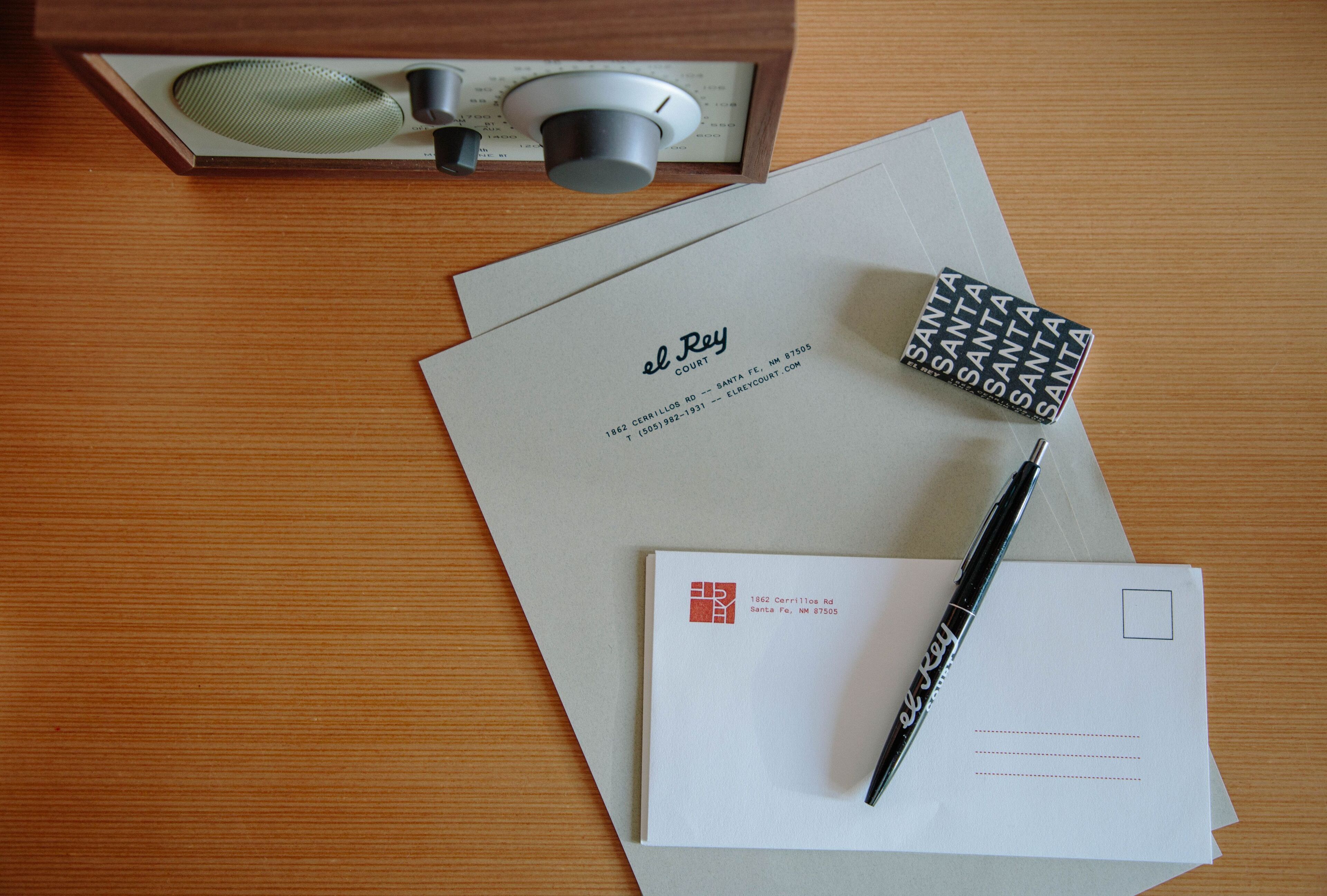 A wooden table with a letter, a pen, and a decorative box.