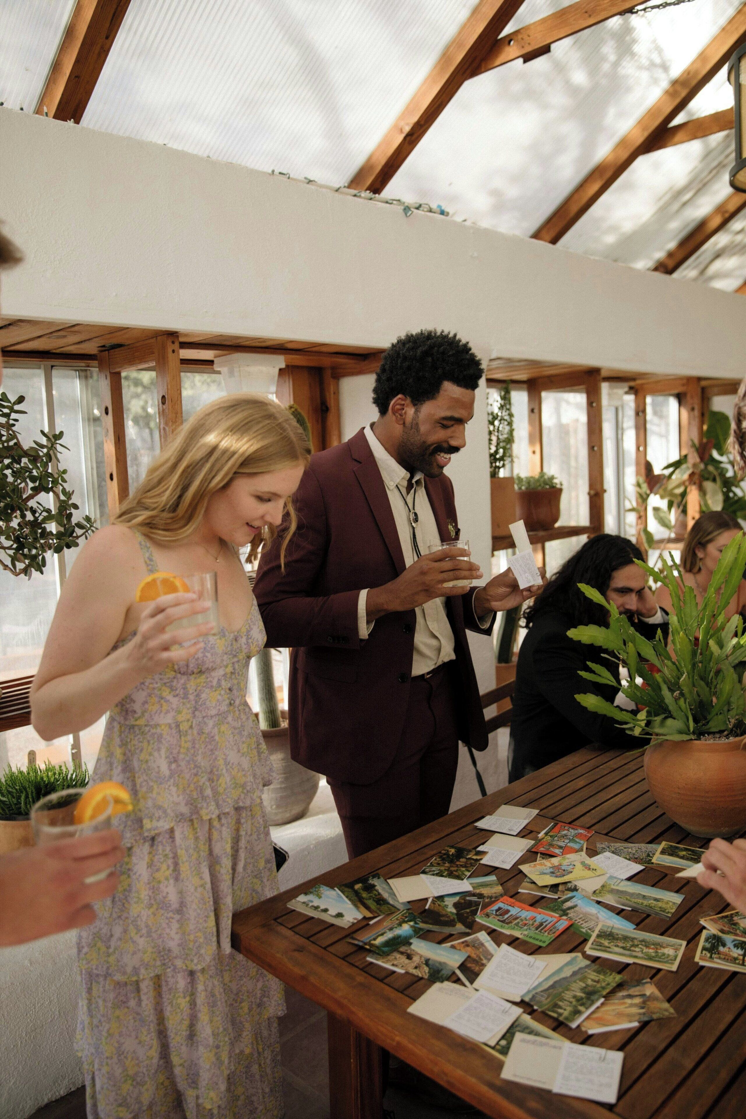 A covered outdoor area with wooden beams, a table with printed materials, and potted plants.