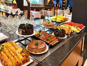 A buffet with various desserts and fruits.