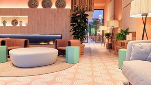 A modern lobby with a fireplace, seating areas, and a large plant. - Montecarlo (Granada)