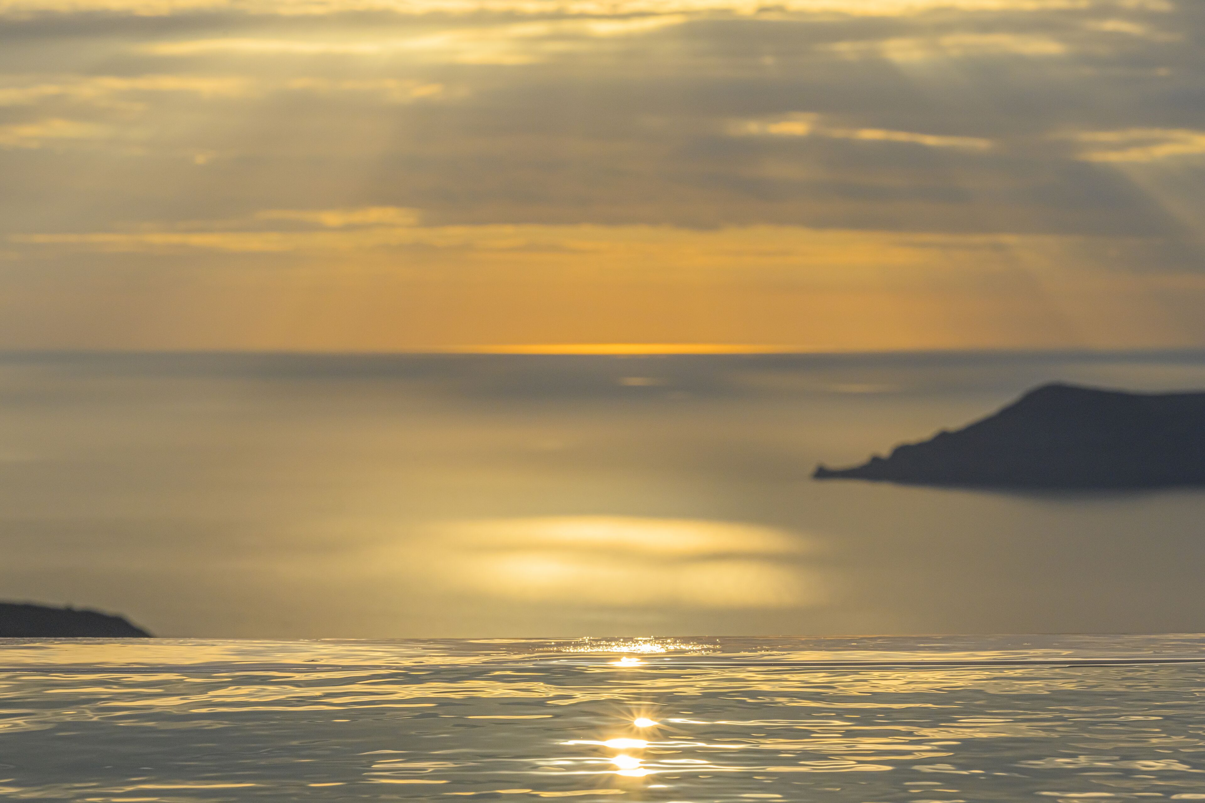 Mar tranquila con reflejos de luz solar en el agua.
