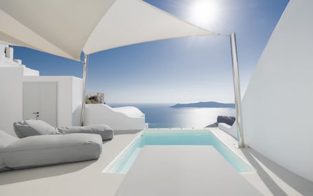 A modern, minimalist room with a pool and a view of the sea.
