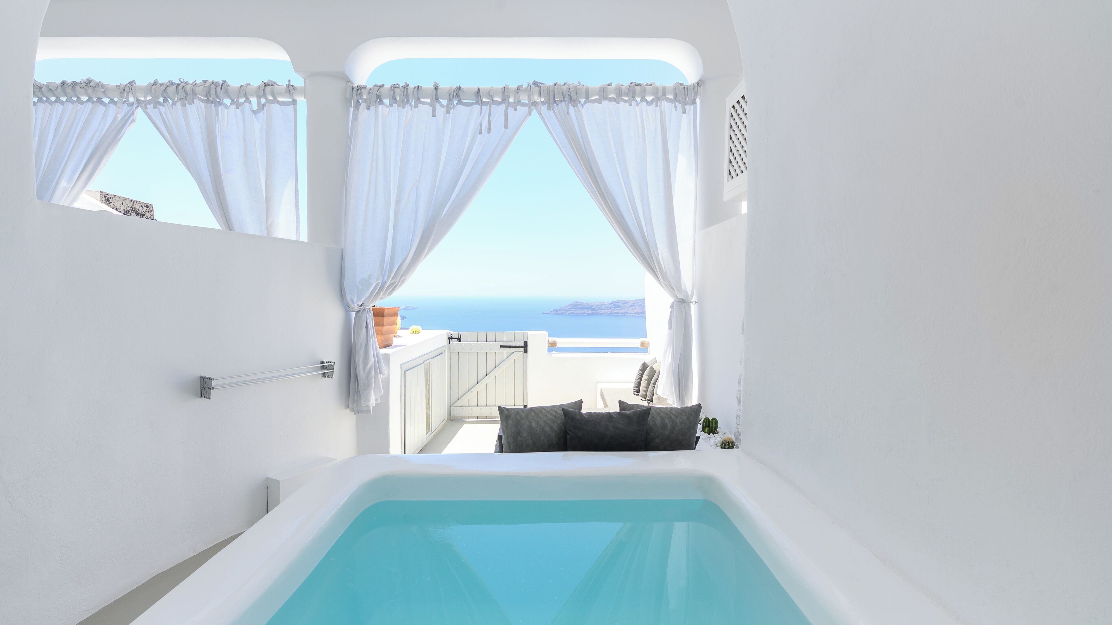 Une salle de bain moderne avec une grande baignoire, des murs blancs et une vue sur la mer.