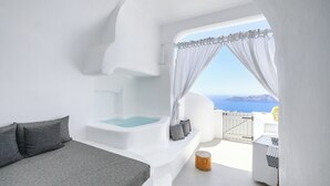 Ein modernes Schlafzimmer mit integriertem Whirlpool, einem Balkon mit Meerblick und minimalistischem Design.