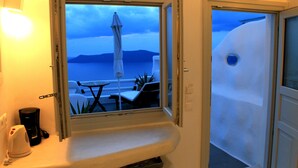 Ein Zimmer mit Meerblick, einem Tisch mit Stühlen und einer weißen Wand.