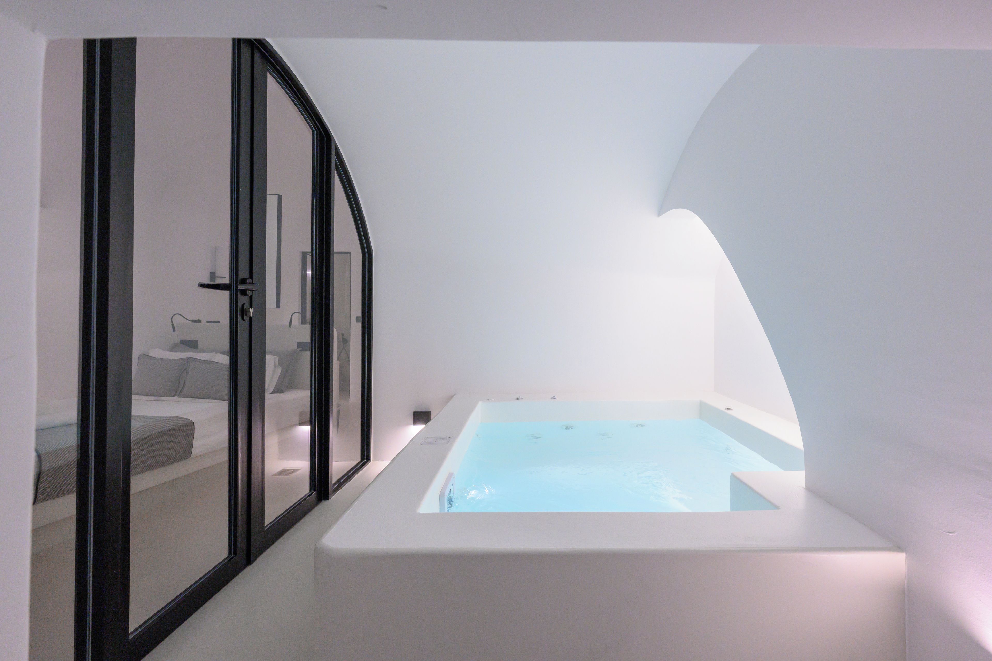 A modern bathroom with a bathtub, a shower area, and a glass-enclosed toilet.