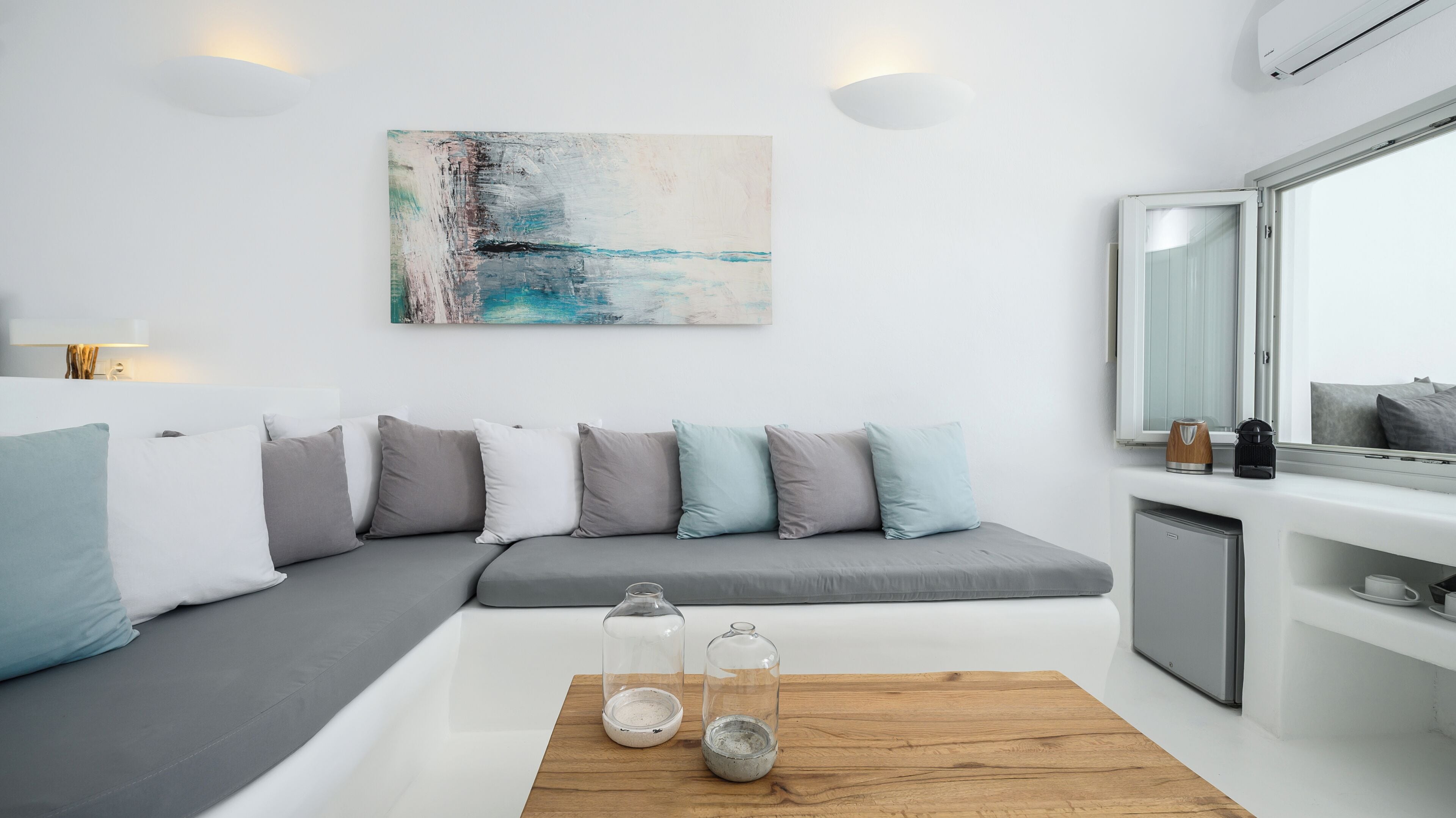 A modern living room with a grey sectional sofa, a wooden coffee table, and a large abstract painting on the wall.