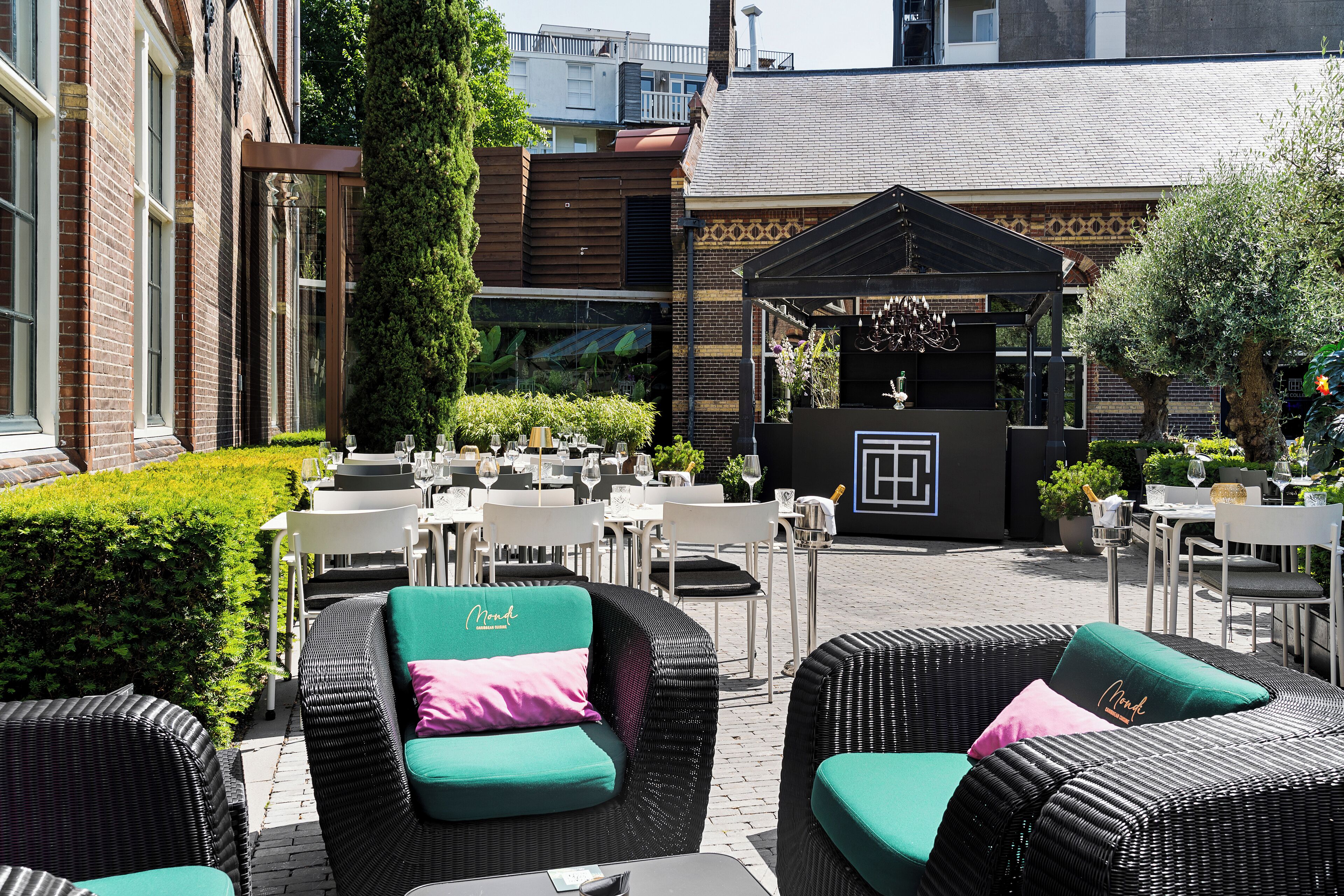 Un espace extérieur aménagé avec des meubles en osier et un petit coin salon abrité.