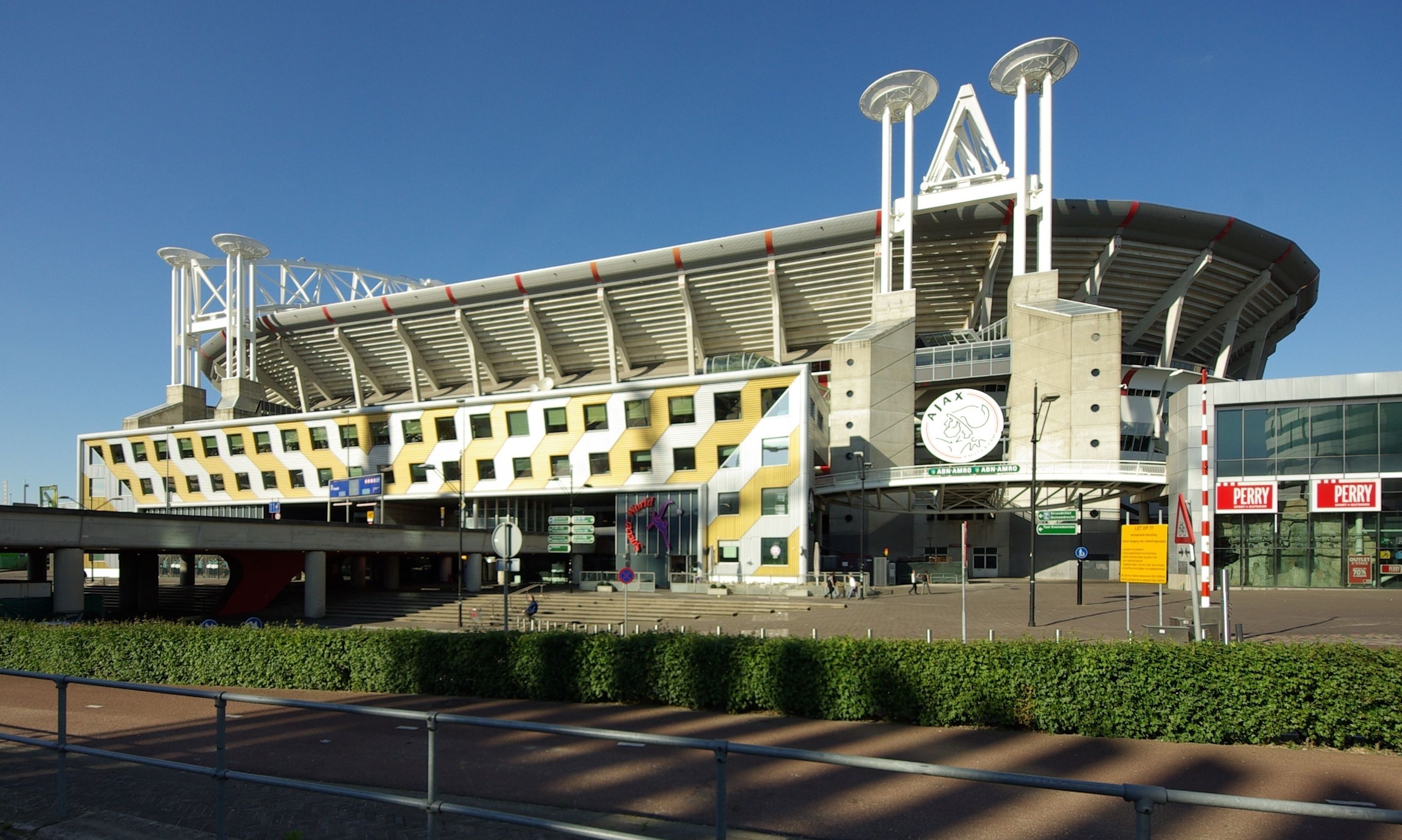 Un estadio moderno con un diseño arquitectónico distintivo, que cuenta con un amplio campo central y múltiples niveles de asientos.