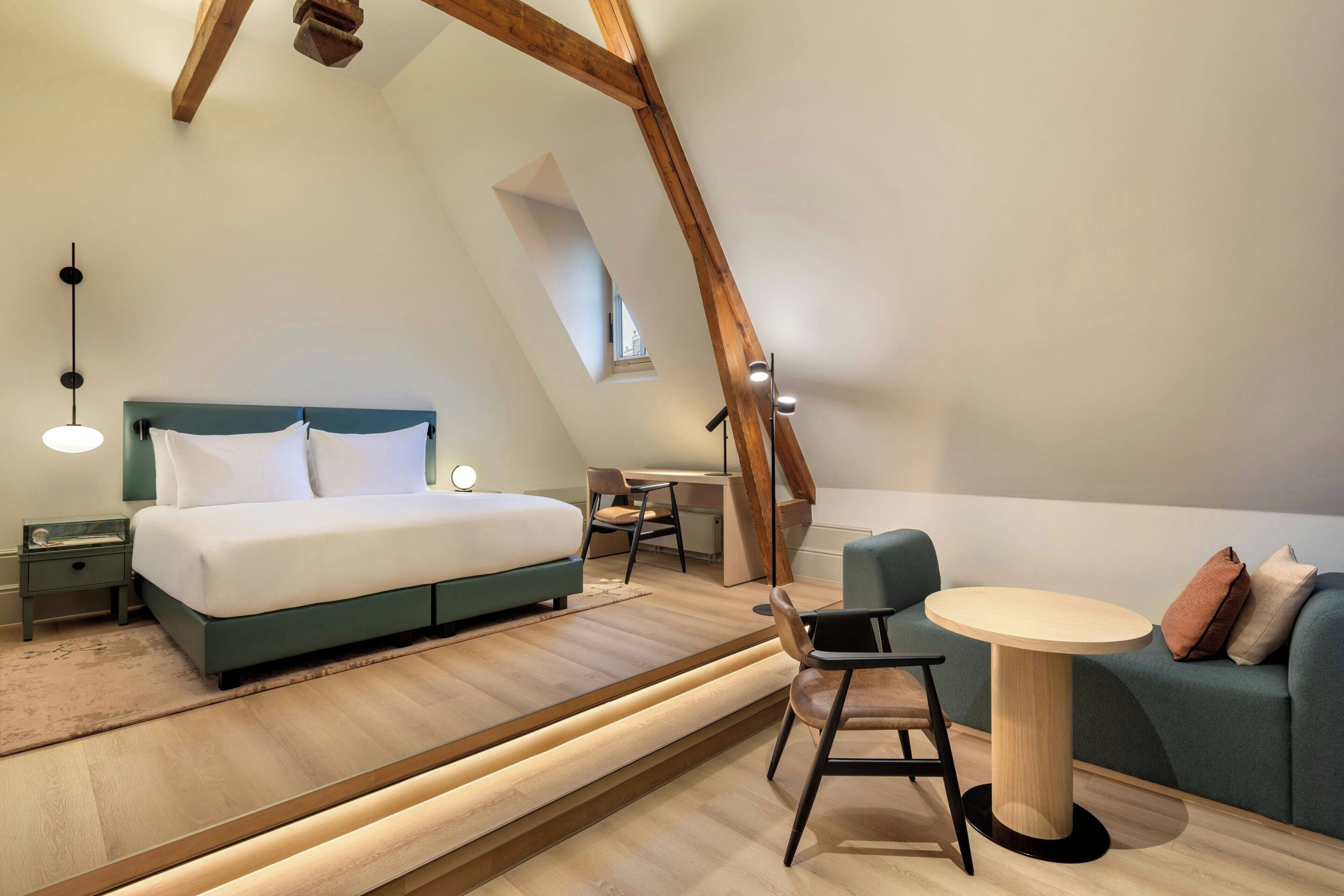 Un dormitorio tipo loft moderno con cama, escritorio y zona de estar.