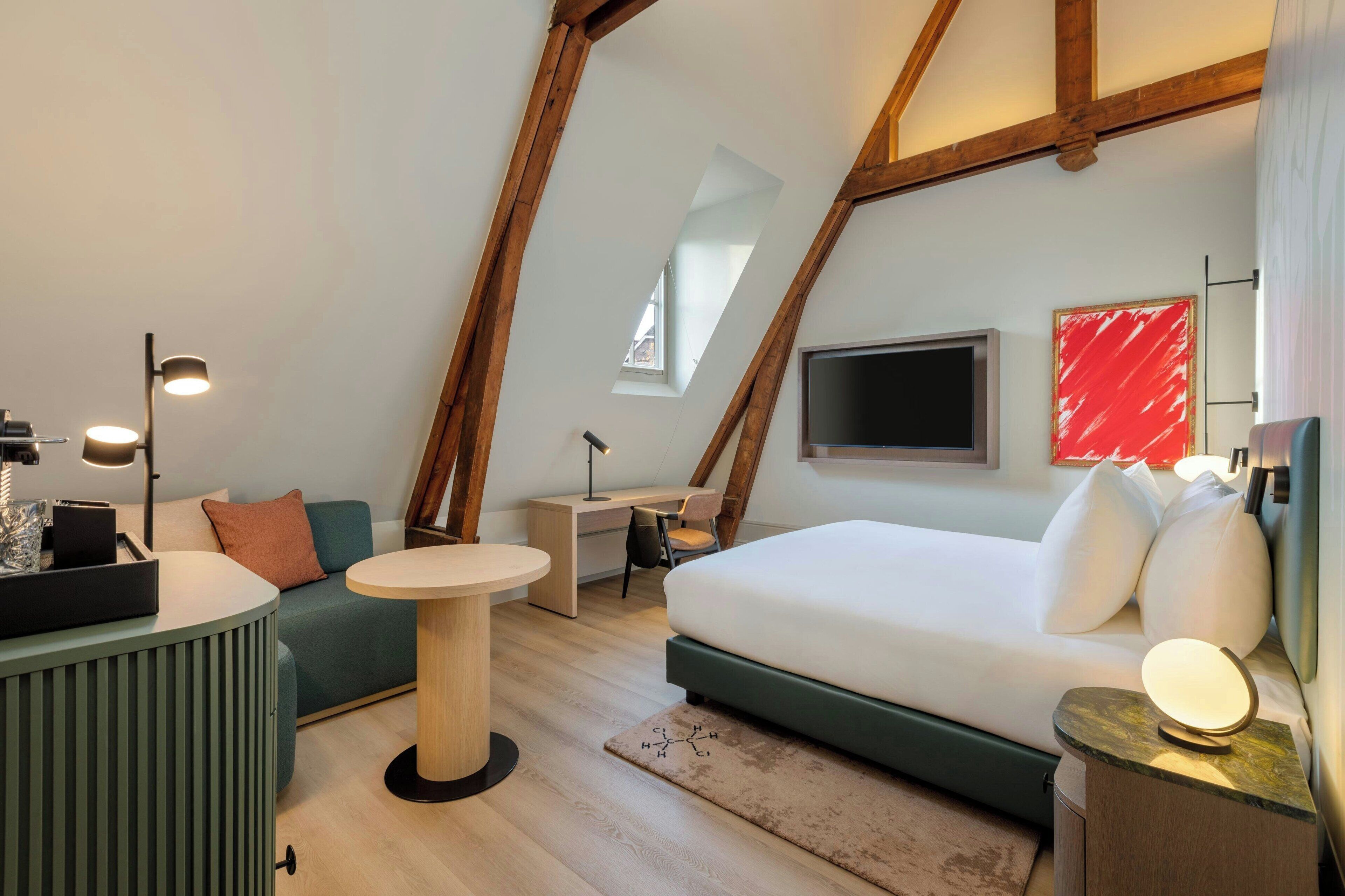 Un dormitorio tipo loft moderno con cama en altillo, escritorio y sofá.