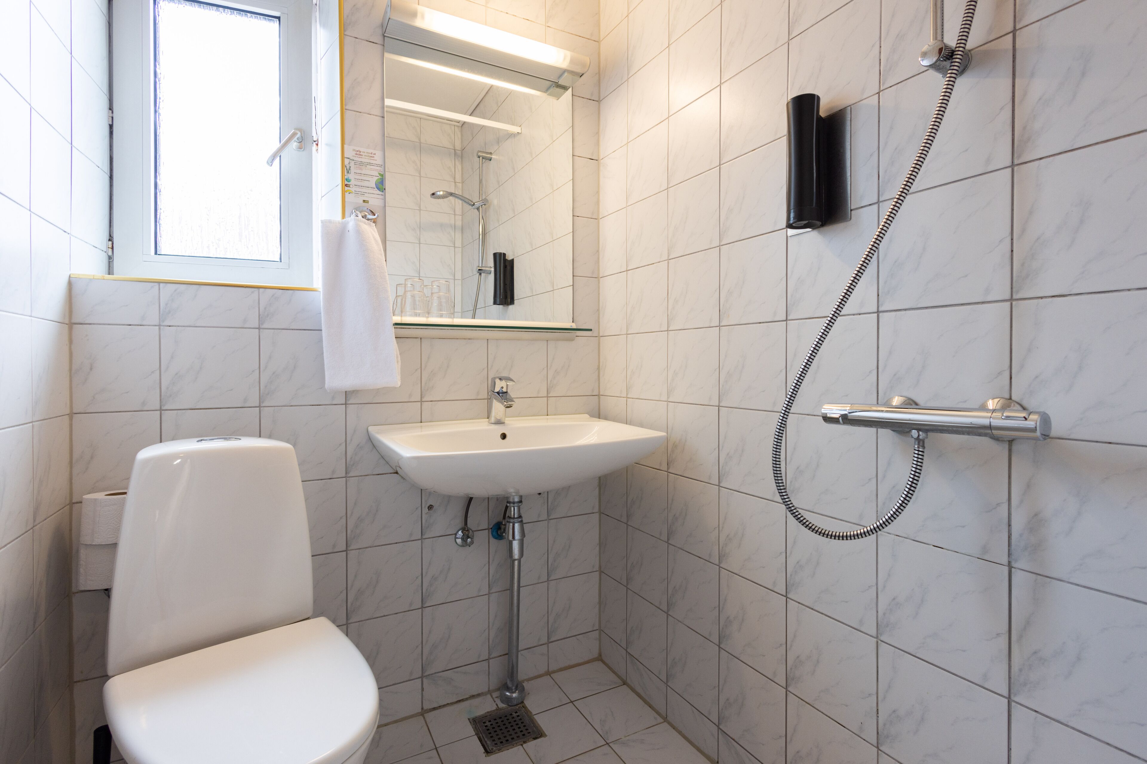 Une salle de bain moderne équipée de toilettes, d’un lavabo et d’une douche.