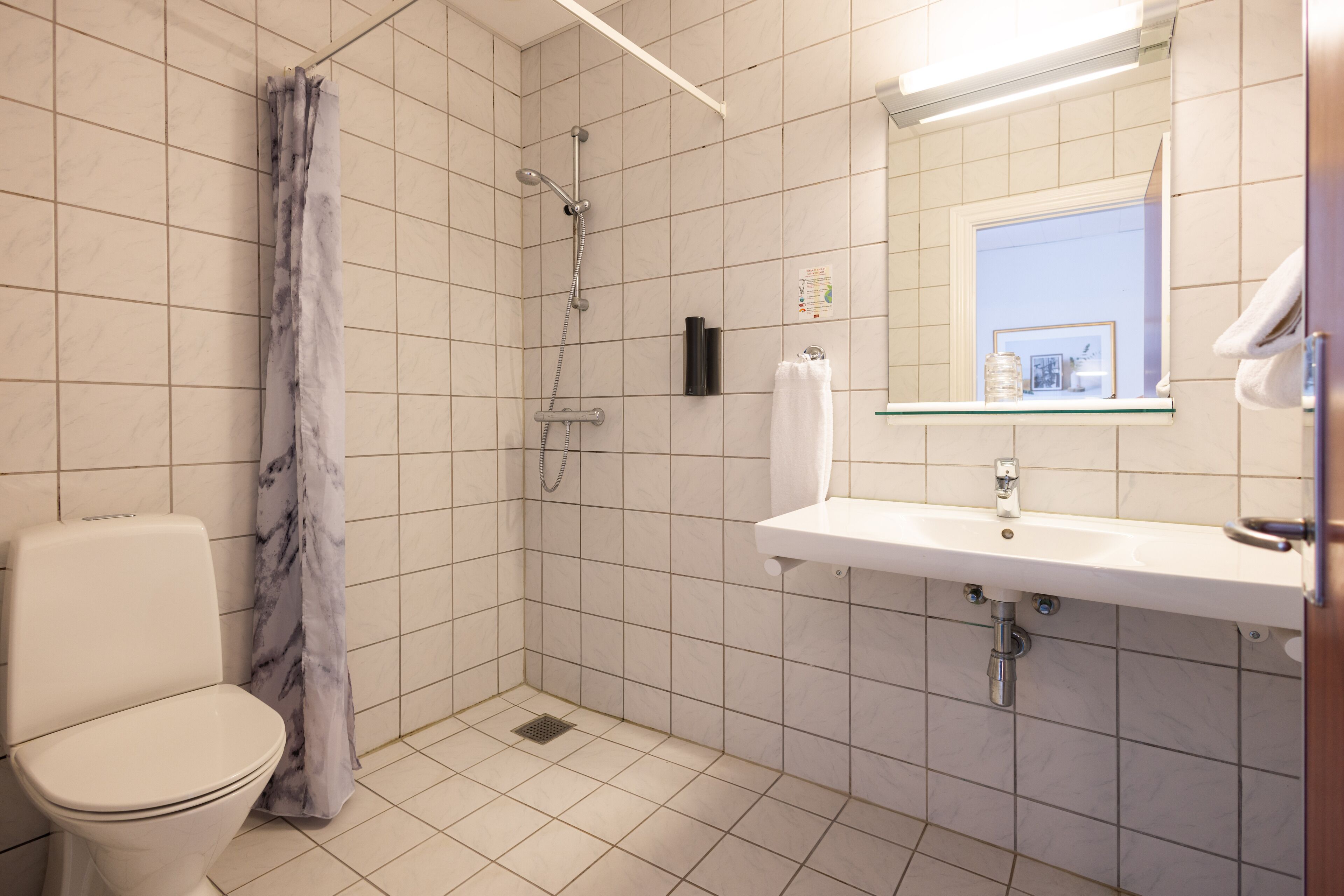 Une salle de bain avec des toilettes, une douche et un lavabo.